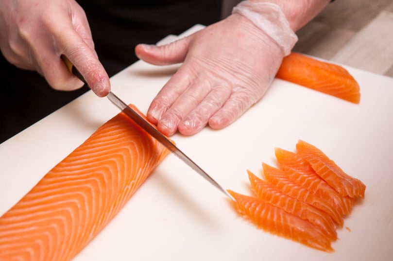 Sushi master, cutting sushi rolls. Making sushi rolls.